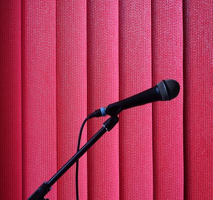 This is a microphone in front of red curtains.