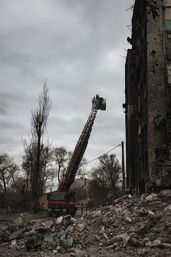 Borodyanka (Borodianka), Ukraine - April 13, 2022: A fire engine ladder extends to inspect a damaged building in Borodyanka in Kyiv Oblast.