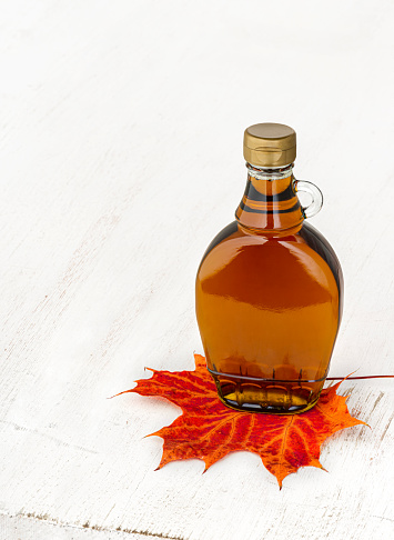 Maple syrup. 
Wooden background. 
Insert your own text or design.