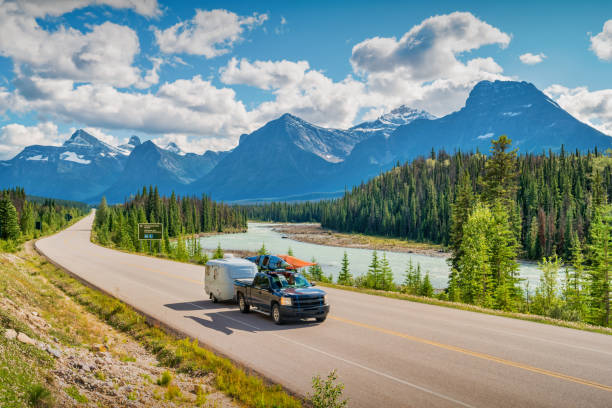 Camper Trailer Road Trip Canadian Rockies Icefields Parkway Travel Pick-up truck with travel trailer and kayaks drives on the Icefields Parkway in Jasper National Park, Canadian Rockies. canada trip stock pictures, royalty-free photos & images