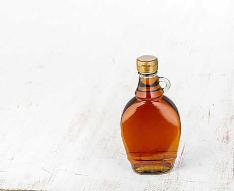 Maple syrup. \nWooden background. \nInsert your own text or design.
