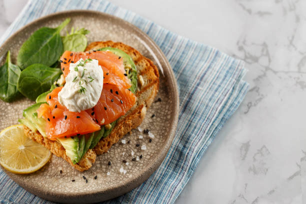 sándwich con aguacate, salmón, queso crema, ensalada fresca en el plato - fruit sale for vegitable fotografías e imágenes de stock