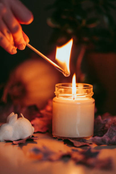 istock A hand with a match lights a candle. 1438994003