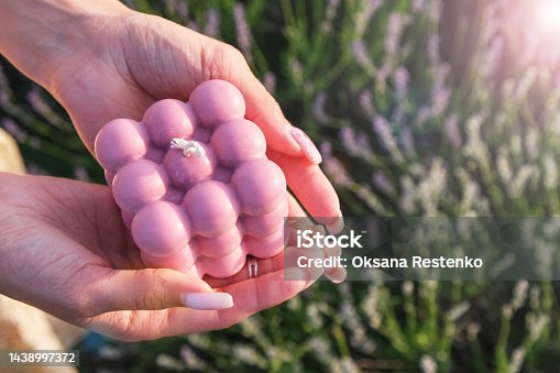 istock Women's hands hold a lavender bubble candle against the backdrop of a lavender field. 1438997372