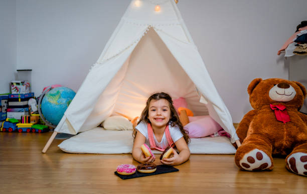 istock Smiling girl with donuts in the tent 1439002617