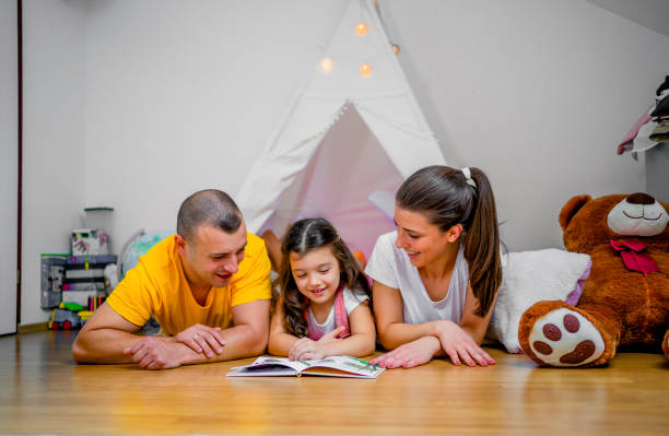 istock Young family reading book together at home 1439002930