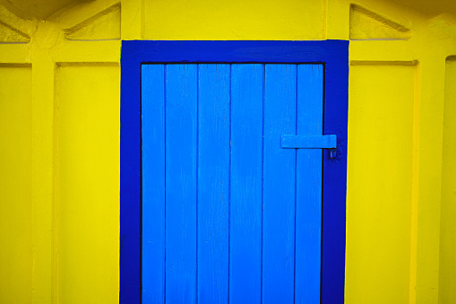 Wooden background. blue and yellow colorful building close up.