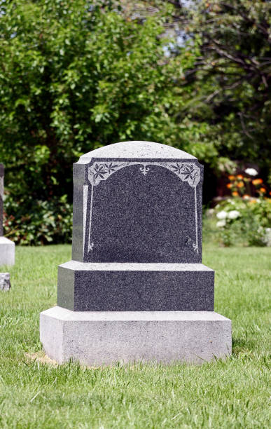 A blank tombstone against a sky with fluffy clouds..