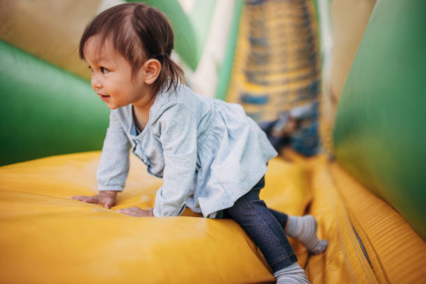 istock Little girl playing in bouncy castle 1439009737