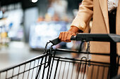 Anonymous Woman in a Coat Pushing a Shopping Cart