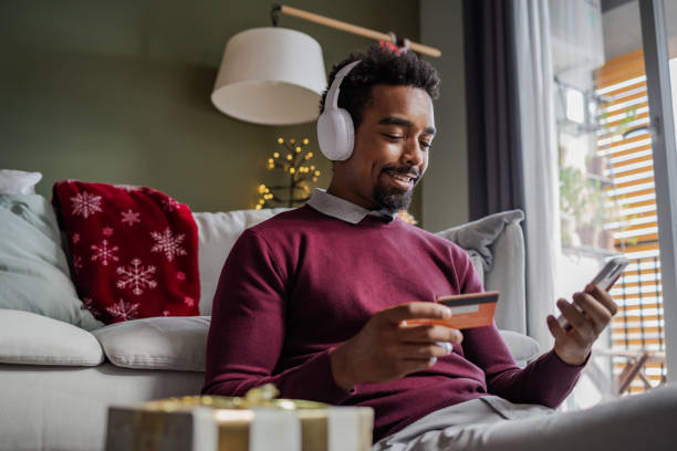 istock Young man doing online Christmas shopping 1439018884