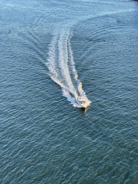 istock Vertical shot of a boat with a trace on the ocean 1439019020