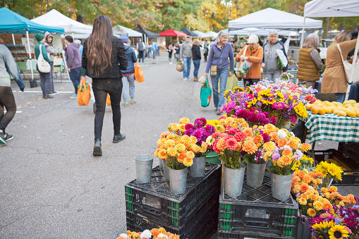 Asheville, North Carolina, USA - 10/15/22:  People shopping for fresh flowers, produce, and other items at the North Asheville Tailgate Market on a Saturday morning.
