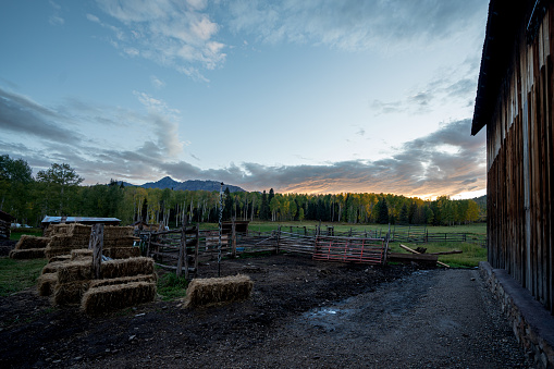 Landscape Rustic Log Cabin and Barn on a Homestead Ranch in the Rocky Mountains in Southwest Colorado Near Telluride under a Dramatic Sunset