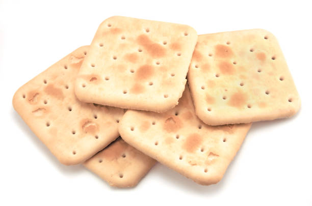 istock Soda cracker stack closeup, large detailed isolated square crisp whole grain saltine crackers macro closeup, military field ration MRE concept, gentle shadows, perforations, saltines flat lay detail studio shot, blank empty horizontal white background cop 1439023664