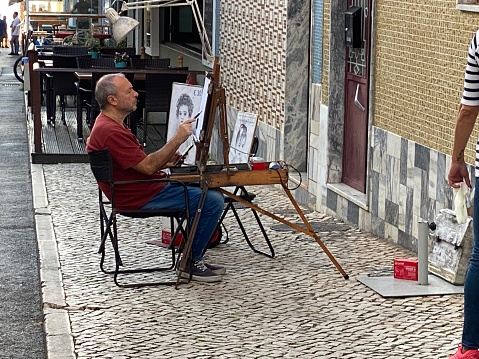 Alvor,  Portugal - October 31,  2022. Paint artist making his art in the streets of Alvor.