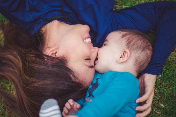istock Mother with a baby boy lying on grass 1439028166