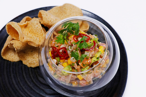 seafood ceviche or tartare in a glass bowl with crackers