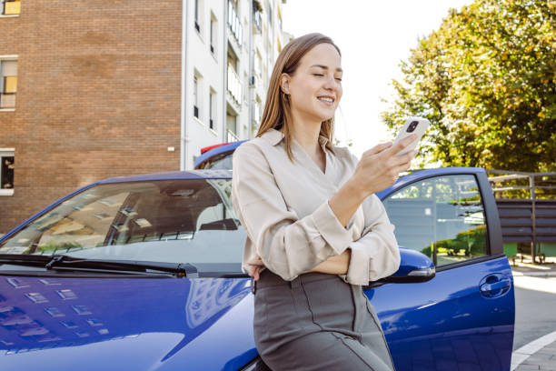 istock Young woman using smart phone by the parked car 1439031855