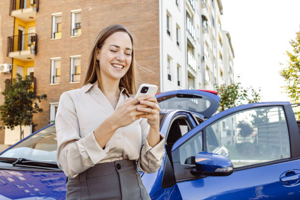 istock Young woman using smart phone by the parked car 1439031966