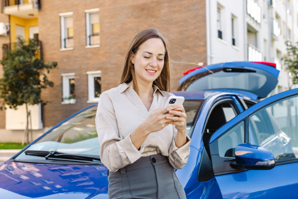 istock Young woman using smart phone by the parked car 1439033202
