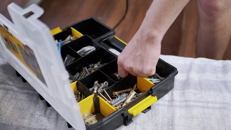 Male Hand Chooses Fasteners and Self-Tapping Screws from a Plastic Organizer. 4K