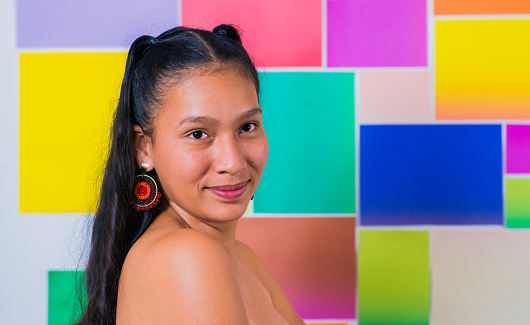portrait of latina woman in studio with cheerful expressions on colorful background
