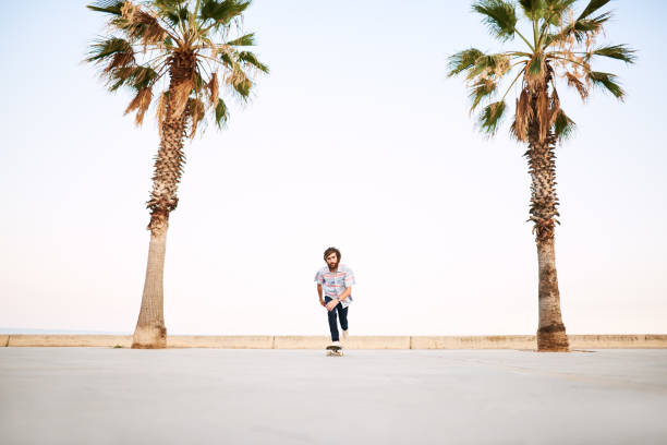 istock Bearded skater riding skateboard towards camera 1439034685
