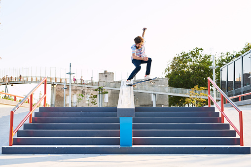 bearded skater doing trick on railing on steps