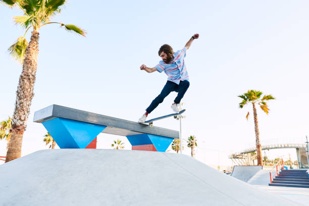 istock Bearded skater performing trick in skate park with arms widened 1439034708