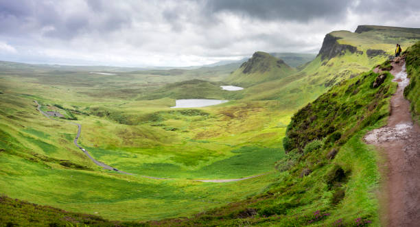 los caminantes de la colina dominan el quiraing y la sinuosa carretera estrecha, desde un sendero de la ladera de la montaña. - road winding road mountain spiral staircase fotografías e imágenes de stock