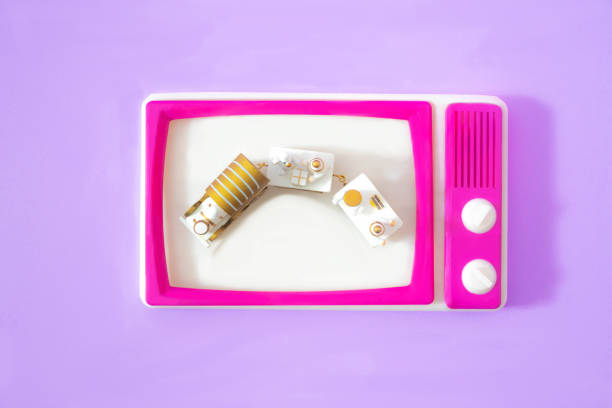 istock A retro tv with magenta frame and old mini train on white screen. Lilac background. Surreal concept for Christmas festivities banner or card. Creative design for romantic movies tv channel. Flat lay 1439039241