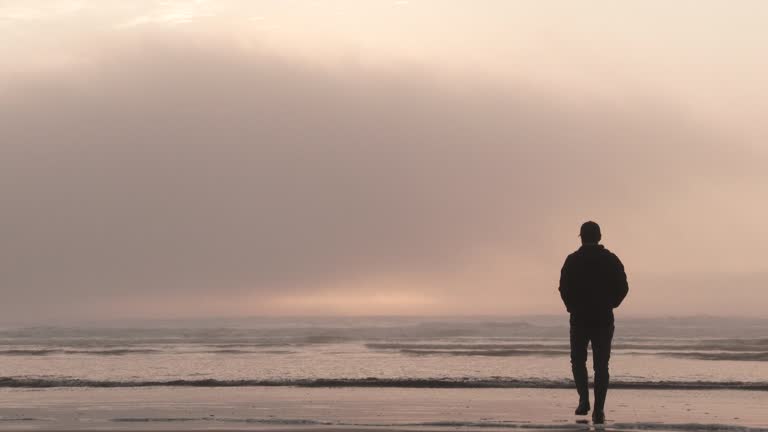 Alone Person Walking Out On Moody Sunset Ocean