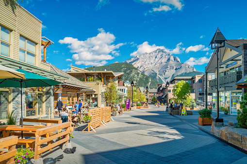 People enjoy a sunny day on the patio of a coffee shop in downtown Banff, Alberta, Canada.
