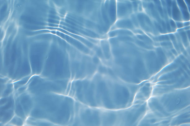 istock Defocus blurred transparent blue colored clear calm water surface texture with splashes and bubbles. Trendy abstract nature background. Water waves in sunlight with copy space. Blue watercolor shining 1439050820