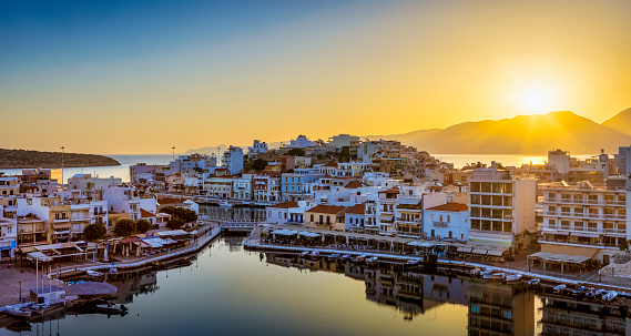 Sunrise over Agios Nikolaos, Crete, Greece. Agios Nikolaos is a picturesque town in the eastern part of the island Crete built on the northwest side of the peaceful bay of Mirabello.