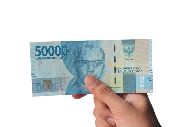 Photo of man's hand showing 50,000 thousand rupiah isolated on white background