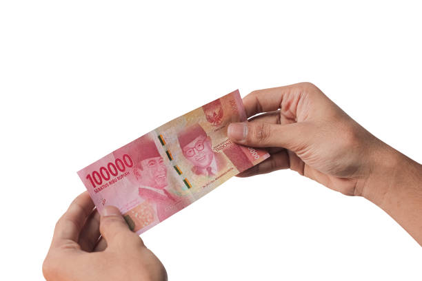 istock Hand holding one hundred thousand rupiah banknote isolated on a white background. financial concept 1439055311