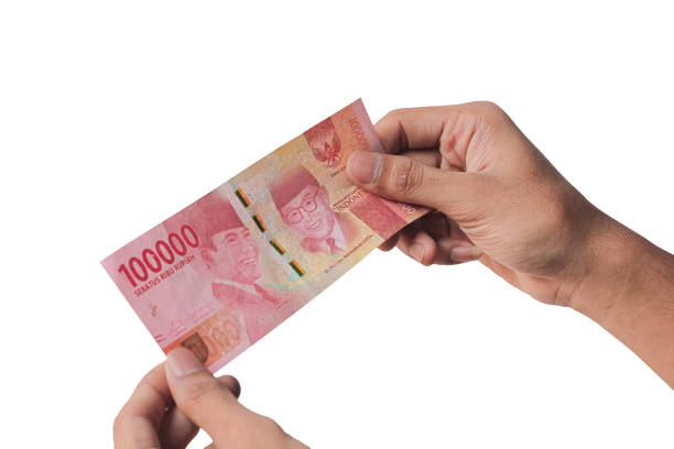 istock Hand holding one hundred thousand rupiah banknote isolated on a white background. financial concept 1439055313