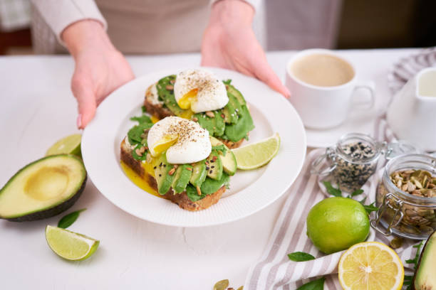 istock Freshly made poached egg and Avocado toasts on light grey background 1439062379