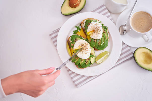istock Freshly made poached egg and Avocado toasts on light grey background 1439062402