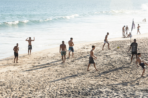 Salvador, Bahia, Brazil - October 22, 2022: Young adults play beach soccer at Farol da Barra beach in Salvador, Brazil on a spring Saturday.