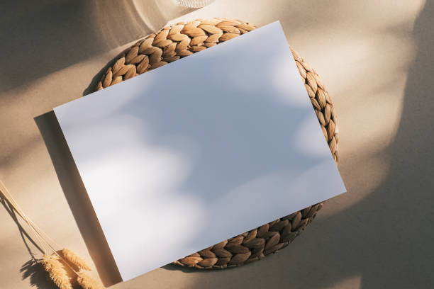 istock Blank white sheet on the beige background in natural sunlight. Minimalist mock-up 1439094917