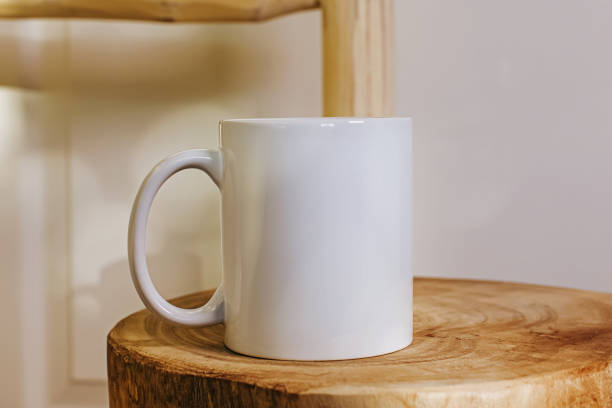 istock White mug mock-up. Cup on the wooden table close-up 1439094925