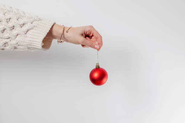 istock Woman's hand holding red decorative Christmas bauble 1439094991