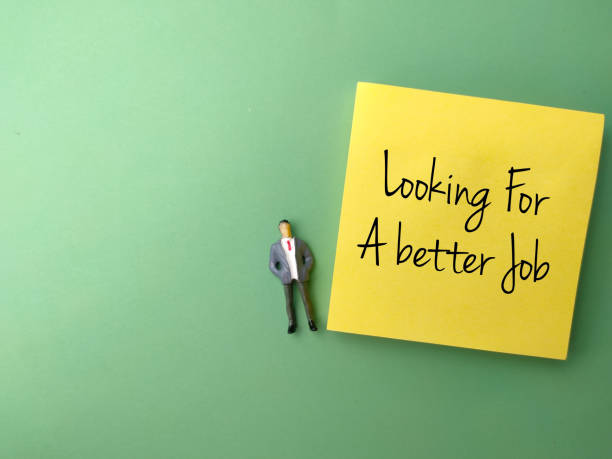 istock Miniature people and sticky note with text Looking For A better Job on green background. 1439108994