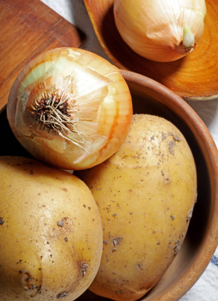 istock raw onions and potatoes on the kitchen table 1439110036