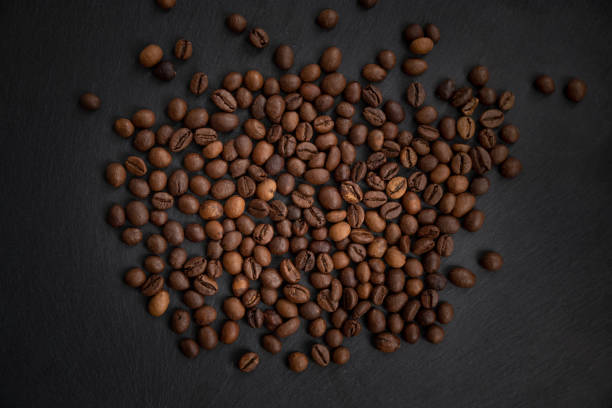 istock Roasted coffee beans scattered on dark background 1439110683
