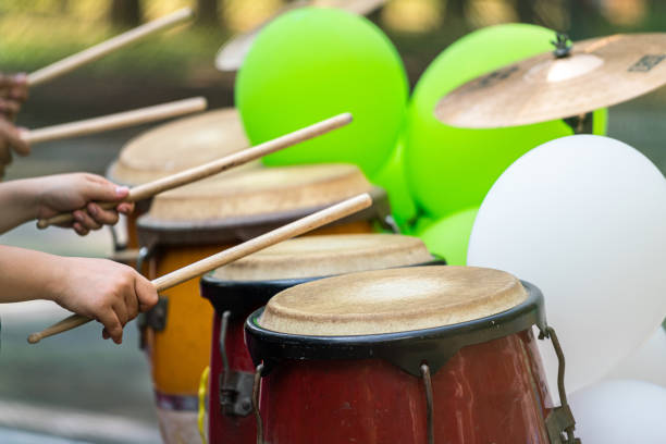 Action of a drummer is using wooden stick hitting on the leather drum during cheering the sport game. Sport and recreation activity scene, close-up and selective soft focus at the object.