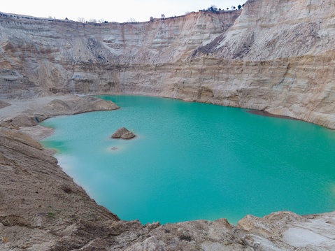 A pale blue crystal clear quarry surrounded by rocky mountains